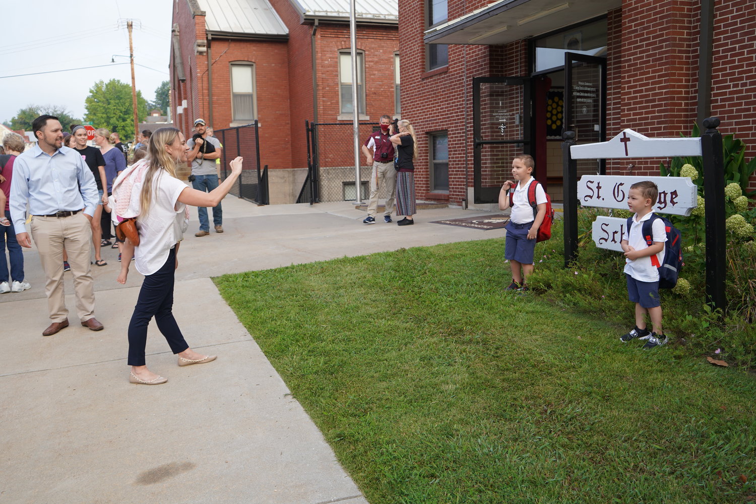 A parent takes photos of her sons on the first day of school at St. George.